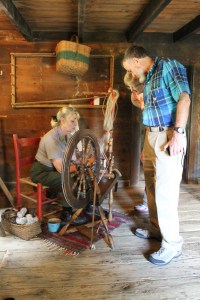 Jackie explains the mechanics of spinning to Brinegar Cabin visitors